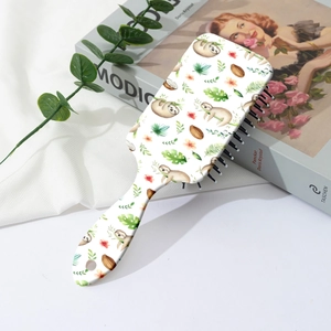 Detail of white air cushion hairbrush featuring cute sloth and tropical leaf prints