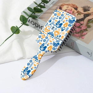 Detail einer weißen Massagebürste mit nordischen Vogel- und Tulpenmotiven