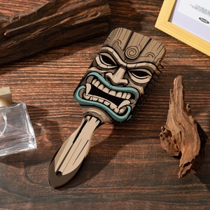 Détail de brosse à cheveux texture bois avec imprimé masque tribal et picots massants