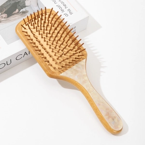 Detailed view of bamboo hairbrush with marbled inlay and rounded bristle tips