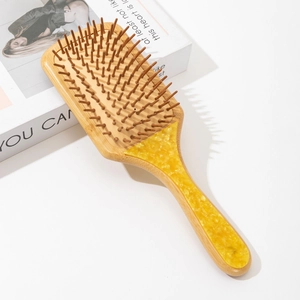 Detailed macro of bamboo hair brush with amber pattern marble inlay on the handle