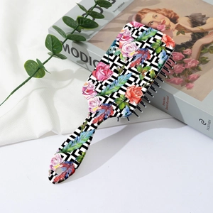 Detail of cushion hairbrush featuring colorful feather and rose print on geometric base
