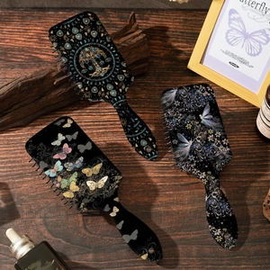 Artistic hair brush set featuring vintage tree of life and butterfly patterns on wood desk