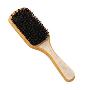 Bamboo hairbrush with marble pattern and mixed bristles on a white background
