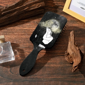 Artistic massage hairbrush with starry sky and female silhouette print on wooden table
