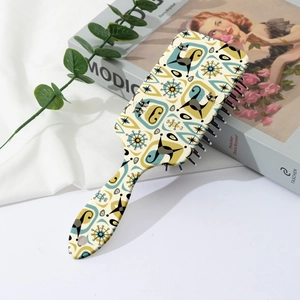 Detail of vintage cat print hairbrush on art book background with ergonomic handle