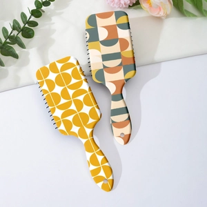 Detail of modern art patterned air cushion hairbrush set with flexible black bristles
