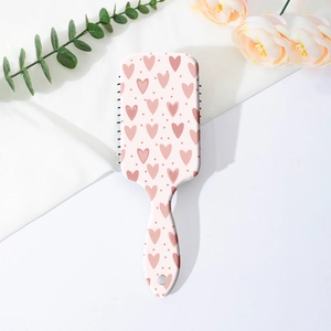 Detail of heart pattern air cushion hairbrush on floral lifestyle background