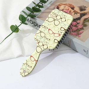 Détail d'une brosse à cheveux avec motif lunettes et manche à trou de suspension