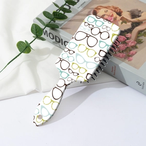 Détail d'une brosse à cheveux carrée avec motifs de lunettes colorés sur fond de tissu doux