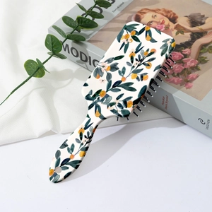 Detail of floral printed cushion hair brush with yellow citrus patterns and hanging hole
