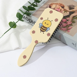 Detail of cute bee print on cream rectangular air cushion massage comb for hair