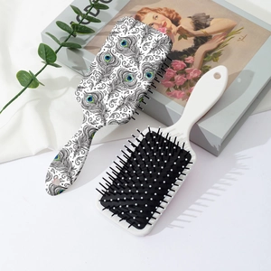 Vintage-Haarbürste mit Pfauenmuster und weiße Massagebürste auf elegantem Grund