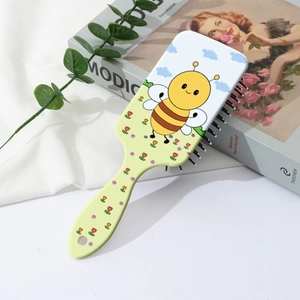 Close-up of a cartoon bee air cushion massage hairbrush with a portable floral design