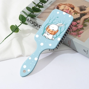Détail de la brosse à cheveux bleue avec imprimé lapin sur surface mate texturée