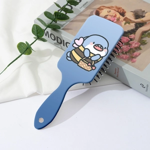 Blue air cushion massage comb with cute bee dolphin print on a clean home background