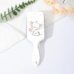 Détail d'une brosse à cheveux blanche avec motif éléphant mignon et coussin d'air