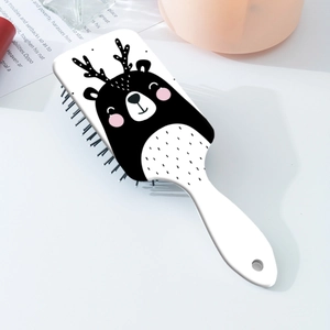 Vue détaillée du motif d'ours de dessin animé sur le dos de la brosse à cheveux portable