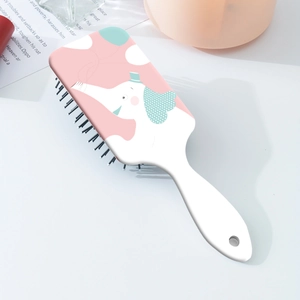 Close-up of a white hairbrush featuring a cute cartoon elephant on a pink background