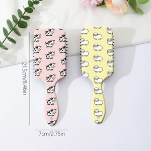 Set of two cute cartoon massage hairbrushes with cow and sheep patterns on a white background
