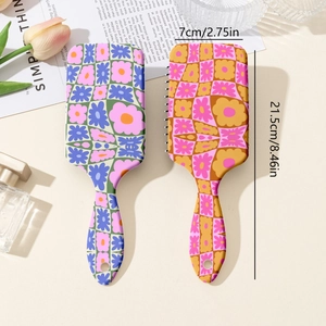 Flat lay of retro floral checkerboard detangling hairbrushes with size measurements