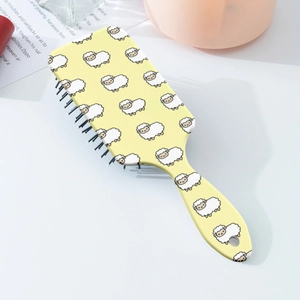 Detail of cute sheep pattern on yellow hair brush with air cushion massage bristles