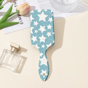 Vue détaillée de la brosse à cheveux à coussin d'air avec motif d'étoiles et décor chic