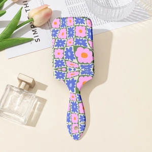 Detail of floral checkerboard cushion hairbrush with ergonomic handle and hanging hole