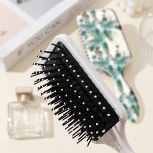Floral print air cushion massage hairbrush with anti-static bristles on lifestyle background