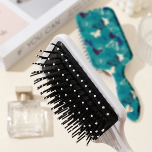 Brosse à cheveux à nœud avec poils doux et coussin d'air massant dans un décor élégant
