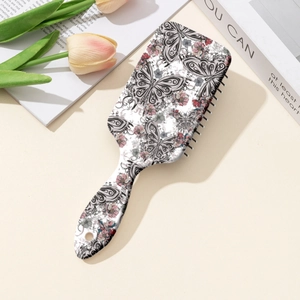 Brosse plate rectangulaire avec papillon noir et imprimé floral rose sur fond beige