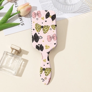 Vue à plat de la brosse à cheveux rose avec nœuds, parfums et décor de fleurs