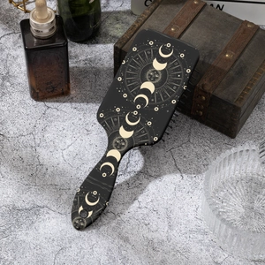 Brosse à cheveux zodiaque noire avec motifs lune et étoiles dorées sur fond élégant