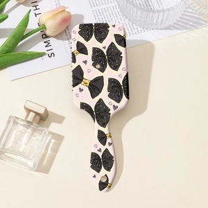 Vue détaillée de la brosse à cheveux à nœuds avec fleurs roses et accessoires de luxe