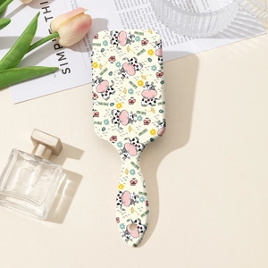 Détail d'une brosse à cheveux rectangulaire avec motifs de vache mignons et fleurs