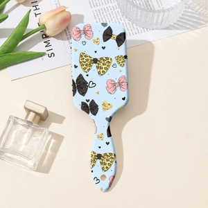 Détail d'une brosse à cheveux avec motif nœud léopard et un trou de suspension pratique