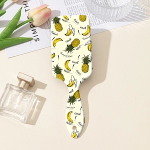 Détail de la brosse à coussin d'air ABS avec motifs ananas et banane sur fond beige
