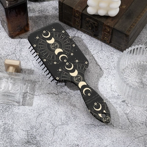 Brosse à cheveux massante avec imprimé constellations et phases de lune sur fond noir élégant