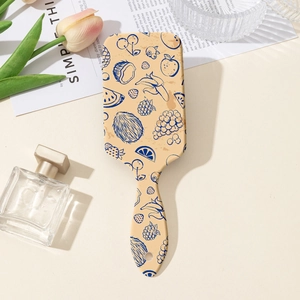 Detail of air cushion hair brush featuring fruit prints and retro illustration style