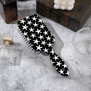Brosse à cheveux à motif d'étoiles noir et blanc sur un comptoir en marbre chic