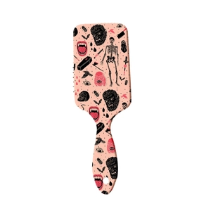 Brosse à cheveux gothique rose avec motifs de crânes et de vampires sur fond blanc