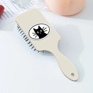 Détail d'une brosse plate crème avec un imprimé chat mignon sur la face arrière