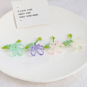 Detail of four colorful handmade beaded flower charms for DIY jewelry making sets