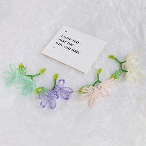 Detail of handmade crystal pearl beaded flower charms in four gradient colors for jewelry
