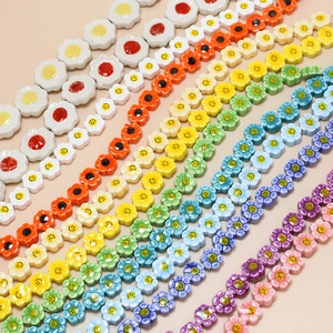 Macro view of colorful ceramic flower beads with smiley faces for DIY jewelry making