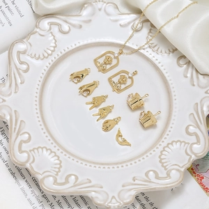Ensemble de pendentifs dorés avec zircone dans un plat en porcelaine sur tissu satiné