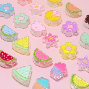 Macro shot of colorful transparent acrylic charms in fruit and candy shapes for DIY crafts