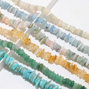Macro detail of colorful irregular natural crystal stone beads on a white tray