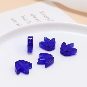 Λεπτομέρεια από βαθύ μπλε ημιδιαφανείς γυάλινες χάντρες σε σχήμα μπουμπουκιού λουλουδιού