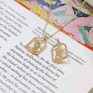 Vue macro de pendentifs rose dorés et collier avec zircon serti sur livre d'art